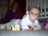 Mary on her belly with blocks strewn about the floor.