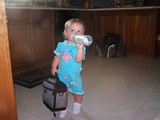 Mary standing in the kitchen drinking from a bottle holding daddy's lunch pail.