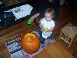 Mary standing by a pumpkin with a scoop.