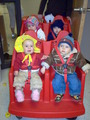 Mary in the daycare buggy in her floppy yellow hat.  She has her hand out to Keegan who is sitting next to her.