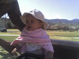 Mary in the brown Jeep with her pink blanket tied around her neck like a cape.  Her 'I love my daddy' shirt is visible below.