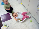 Mary in a plastic container at daycare looking confused.