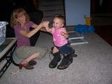 Mary putting on daddy's Army boots with mommy holding her hand.