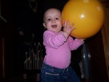 Mary holding her yellow vinyl ball up next to her head.
