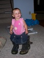 Mary in daddy's boots, standing with no help looking at the camera inquisitively.