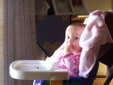Mary sitting in her highchair eating her lunch.