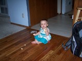 Mary sitting on the floor eating her biscuit.