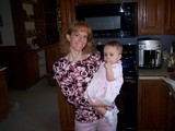 Mommy holding Mary who is wearing her pretty pink dress.