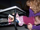 Mary crawling under the coffee table through the magazine rack.