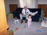 Mary in her pink pajamas running away from Papa who is dressed in a tie.