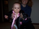 Mary standing with mommy holding her.  She is wearing a silk robe that is black with pink trim.
