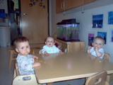 Mary sitting at the kids table at daycare.  She is at the head of the table.