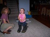 Mary in daddy's boots, looking at the camera, smiling.