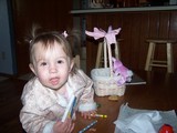 Mary leaning in to the camera with her Easter basket behind her.  She is wearing a nice jacket.