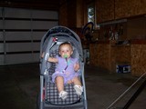 Mary sitting in her stroller pulling the tray down into place.