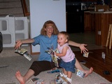 Mary crouching down to throw coupons in the air with mommy throwing coupons behind her.