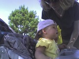 Mary sitting in her stroller with her baseball cap on backwards.