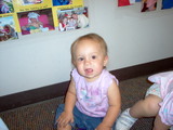 Mary sitting on the carpet looking up at the camera.